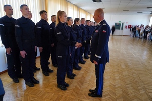 Komendant wita się symbolicznie z nowoprzyjętymi policjantami poprzez podanie ręki policjantce stojącej jako pierwsza w szeregu