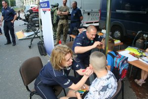 na stanowisku policyjnym policjanci maluja twarze dzieci