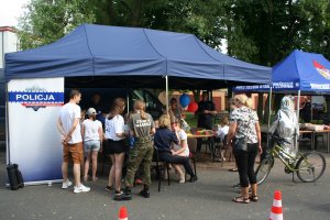 stanowisko policyjne przy którym stoja uczestnicy festynu i rozmawiają z policjantami