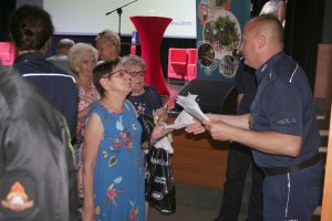 policjant zbiera enkiety od uczestników debaty po jej zakończeniu