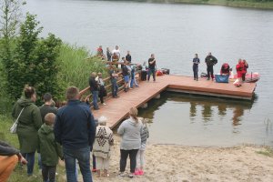 policjanci i ratownicy stojąc na pomoście przeprowadzają pogadankę na temat bezpieczeństwa