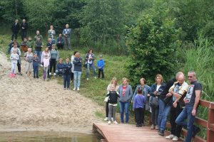 stojący nad jeziorem uczestnicy pikniku