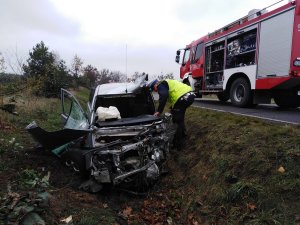 policjant stoi przy rozbitym pojeździe