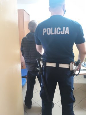 policjant trzyma zatrzymanego
