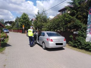policjant stoi przy kontrolowanym pojedzie