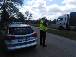 policjant mierzy prędkość poruszających się pojazdów