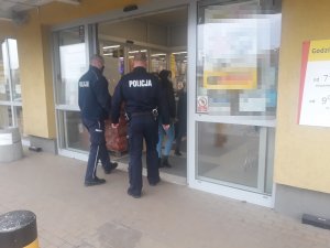 dwóch policjantów wchodzi do placówki handlowej