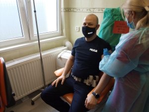 policjant przymuje szczepionke