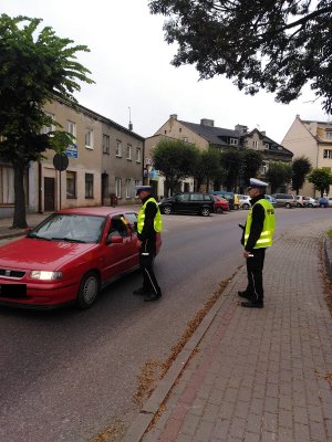 policjant sprawdzający trzeźwość kierowcy samochodu