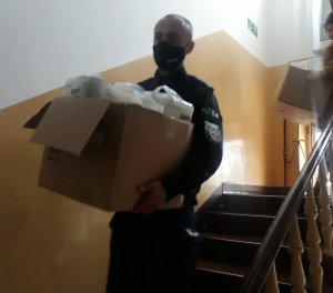 policjant niosący karton z podarunkami