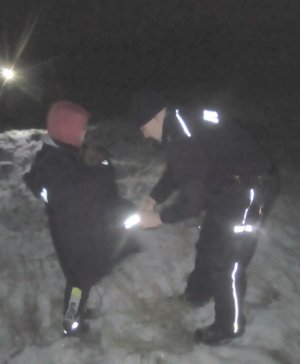 policjant ubiera odnolezionego chłopca w kurtkę