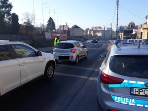 policjant stoi przy samochodzie i sprawdza stan trzexwości kierowcy