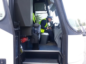 policjant siedzi na miejscu kierowcy autokaru