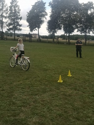 policjant nadzoruje jadących na rowerze dzieci