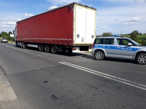 samochód ciężarowy stojący na poboczu, a obok stoi radiowóz