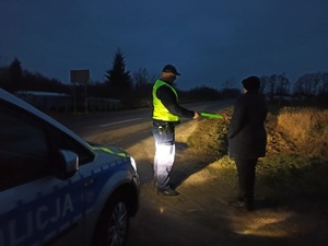 policjant wręcza opaske odblaskową pieszemu