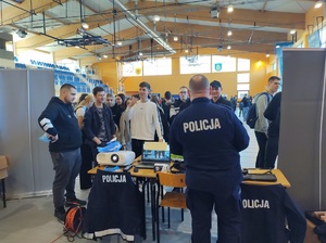 policjant rozmawia z uczestnikami na stanowisku policyjnym