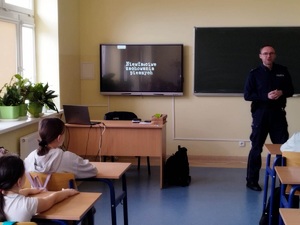 policjant prezentuje film profilaktyczny pn. niewłaściwe zachowania pieszych