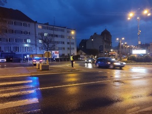 policjant stoi na drodze i kieruje ruchem