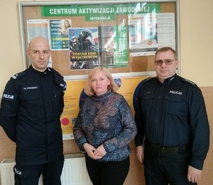 policjanci stoja na tle tablicy ogłoszeń gdzie wywieszony jest plakat o naborze do policji