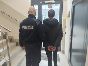 policjant prowadzi zatrzymanego