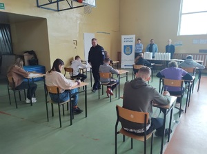 policjant przyglada sie jak zadownicy rozwiązuja test