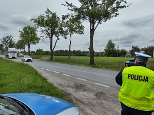 policjant na drodze mierzy prędkość pojazdów