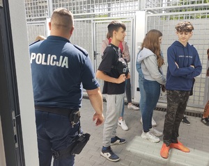 policjant z uczniami w pomieszczeniach przeznaczonych dla psów słuzbowych