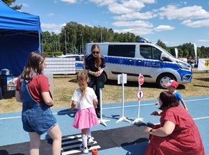 policjantka pokazuje na sygnalizacji świtlnej zielone światło