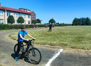 dziecko na rowerze, dalej stoi policjant