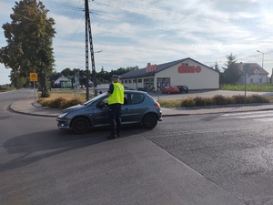 policjant na drodze sprawdza trzeźwośc kierowcy