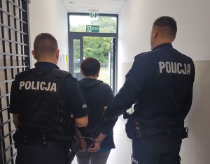 policjanci prowadza zatrzymana kobietę