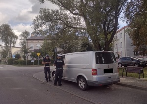 policjanci stoją przy kontrolowanym pojeździe