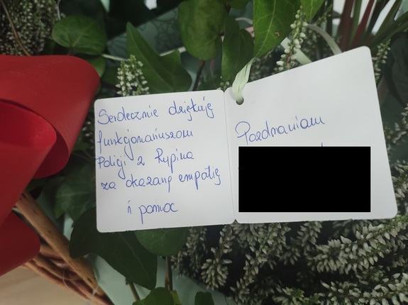 zdjęcie bileciku dołączonego do kwiatów z podpisem o treści:„Serdecznie dziękuję funkcjonariuszom Policji z Rypina za okazaną empatię i pomoc. Pozdrawiam…”.