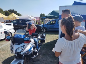 dziecko siedzace na policyjnym motocyklu