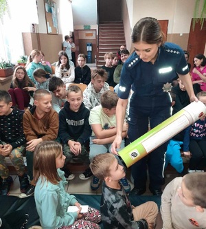 policjantka pokazuje dziecku tube edukacyjną