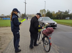 policjantka wręcza opaske odblaskową