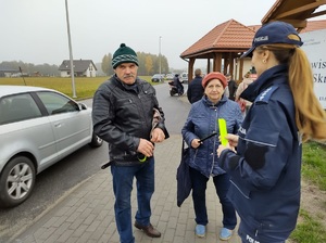 policjantka wręcza opaske odblaskową