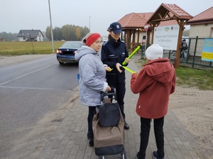 policjantka wręcza opaske odblaskową