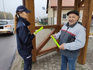 policjantka wręcza opaske odblaskową