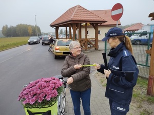 policjantka wręcza opaske odblaskową