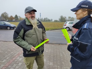 policjantka wręcza opaske odblaskową