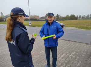 policjantka wręcza opaske odblaskową