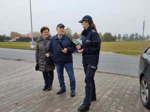 policjantka wręcza opaske odblaskową