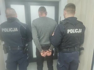 dwoch policjantów prowadzi zatrzymanego