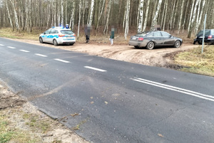 radiowóz stojący przy drodze, oraz dwa pojazdy