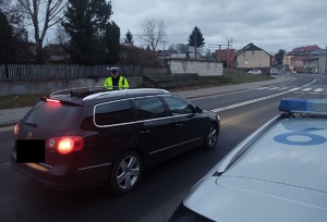 policjant stoi przy zatrzymanym pojezdize