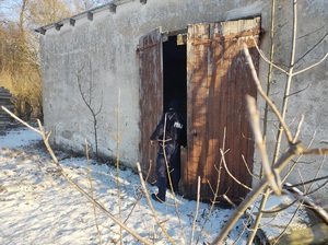 policjant zagląda do opuszczonego budynku