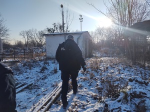 policjant idzie w kierunku opuszczonego budynku