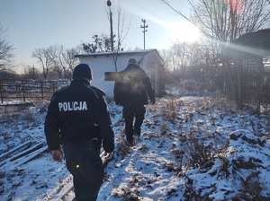 dwóch policjantów idzie w kierunku opuszczonego budynku